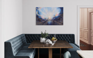 Soul's Return, hanging over a table and L shaped cushioned bench in a kitchen with white walls. a textured painting with light rays shining out from the center representing the soul's return to one's self, or the universe. Blue, pink, white, dark blue, textured painting. Ephemeral art, art with meaning, soul artist. Jennifer Tepper Fine Art.
