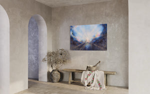 Soul's Return, hanging over a rustic wood bench with dried plants, in an entry with rounded doorways and stone walls. a textured painting with light rays shining out from the center representing the soul's return to one's self, or the universe. Blue, pink, white, dark blue, textured painting. Ephemeral art, art with meaning, soul artist. Jennifer Tepper Fine Art.