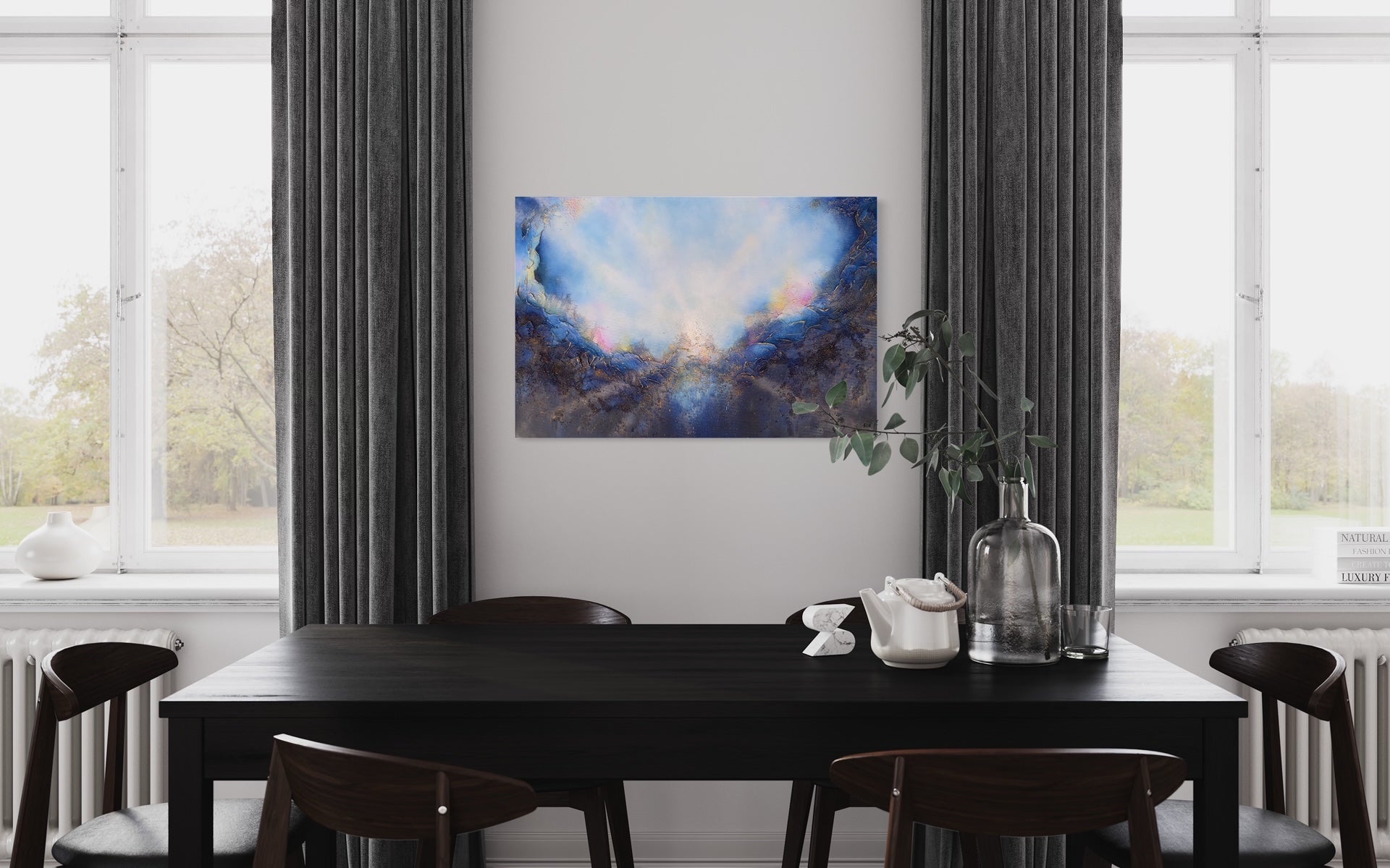Soul's Return, hanging over a modern black table and chairs, with windows with floor length curtains on either side. a textured painting with light rays shining out from the center representing the soul's return to one's self, or the universe. Blue, pink, white, dark blue, textured painting. Ephemeral art, art with meaning, soul artist. Jennifer Tepper Fine Art.