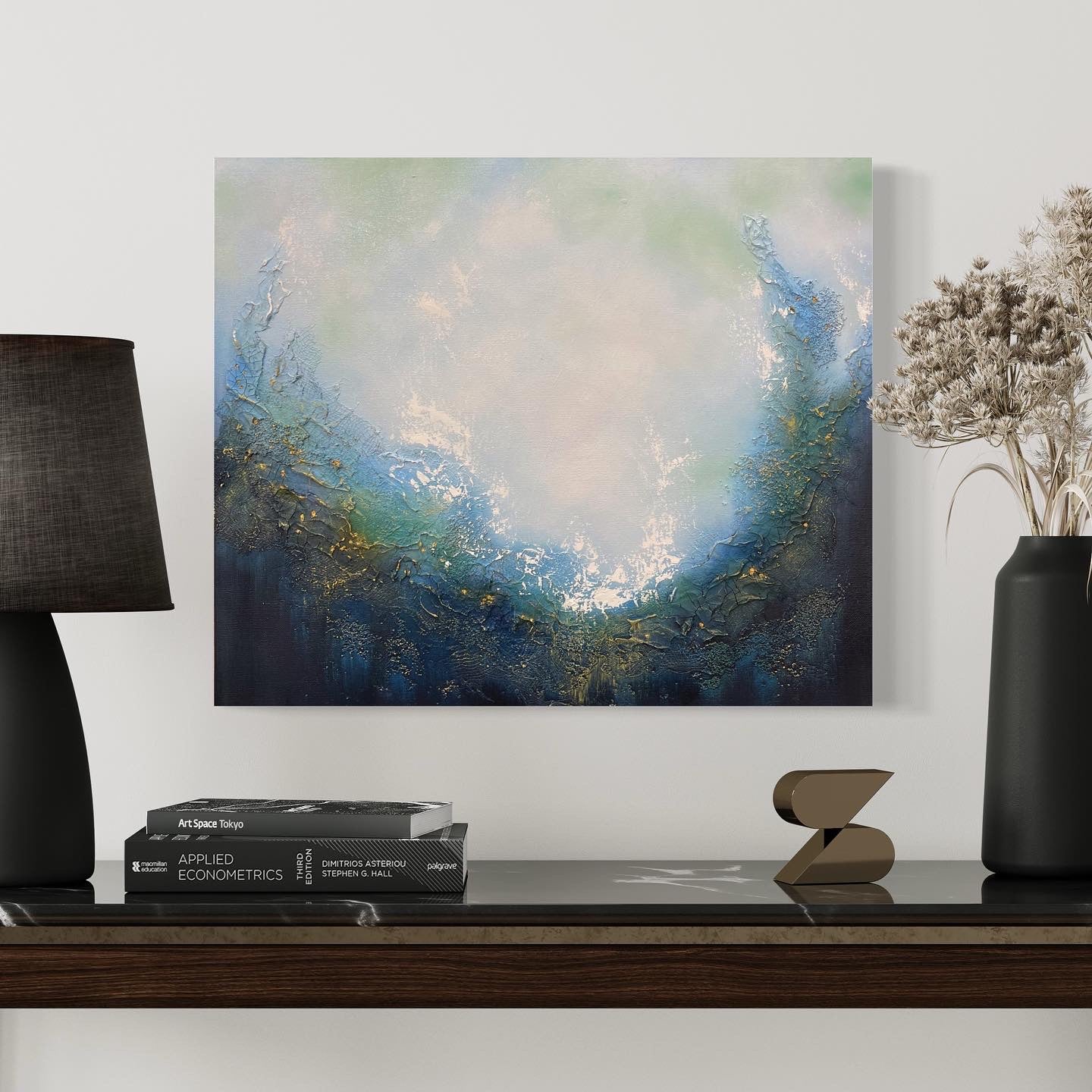 This stunning original abstract painting evokes a feeling of soulful peace and beckons a return to your spiritual center. Dive in and explore this portal which invites personal reflection with its powerful imagery of a magical portal opening up to a realm of endless possibilities.  Painting hangs over a table with books and a black lamp.